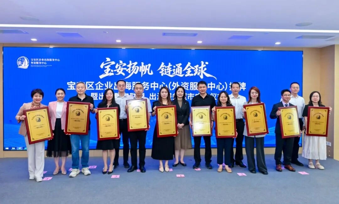 港丰集团与其他优秀服务机构一同上台，从市区领导手中接过牌匾并合影留念